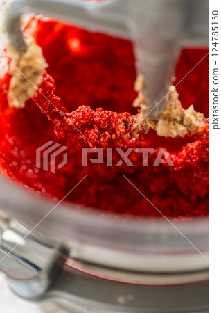 The maple syrup and egg mixture is added to the creamed butter and brown sugar in the mixing bowl. The wet ingredients blend together to create a vibrant base for the Classic Red Gingerbread Dough. The maple syrup and egg mixture is added to the creamed butter and brown sugar in the mixing bowl. The wet ingredients blend together to create a vibrant base for the Classic Red Gingerbread Dough. 124785130