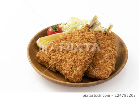 Fried horse mackerel served on a round wooden plate on a white background 124785202