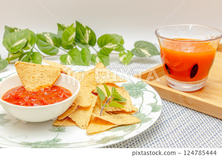 Corn tortilla chips, salsa sauce and vegetable juice Corn tortilla chips, salsa sauce and vegetable juice 124785444
