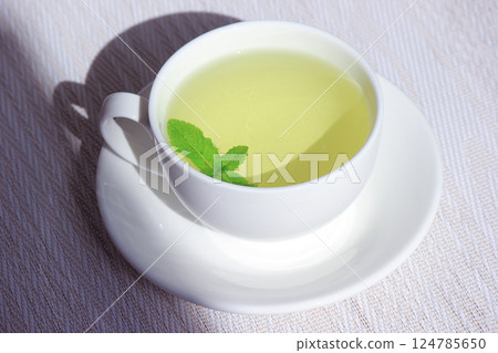White cup and saucer with mint tea White cup and saucer with mint tea 124785650