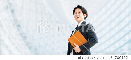 微笑的男性商人拿著活頁夾 微笑的男性商人拿著活頁夾 124786112
