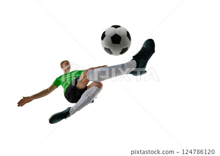Low angle of focused man, dressed sport uniform, soccer player defending goal with tackle against white studio background. 124786120
