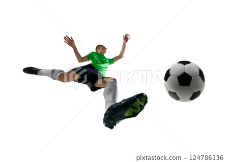 Low angle of male athlete, dressed sport uniform, soccer player leaping to kick ball in motion against white studio background. Low angle of male athlete, dressed sport uniform, soccer player leaping to kick ball in motion against white studio background. 124786136