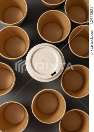 New beige kraft paper cups and reusable bamboo coffee cup on a gray top view, mockup 124786234