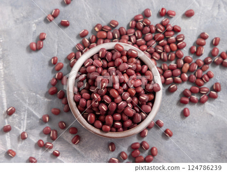 Bowl full of dried azuki beans on gray top view. East Asian legumes, vegetarian protein source Bowl full of dried azuki beans on gray top view. East Asian legumes, vegetarian protein source 124786239
