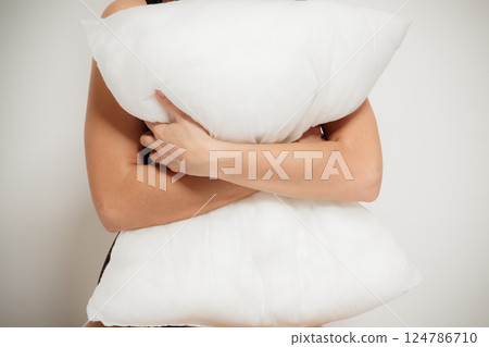 Closeup of white pillow in arms in the bedroom Closeup of white pillow in arms in the bedroom 124786710