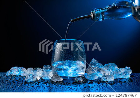 Vodka pours from bottle to glass. Vodka pours from bottle to glass. 124787467