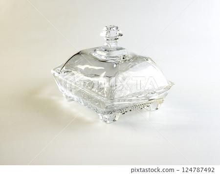 Glass container with lid for storing butter on a white background. 124787492