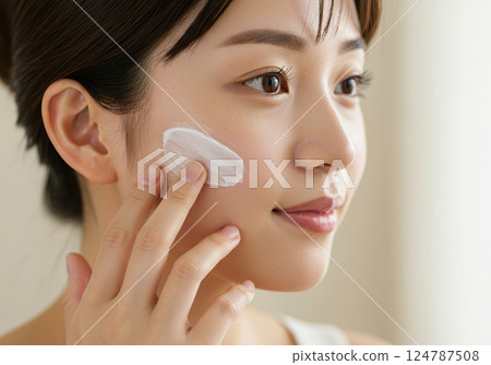 A young Japanese woman applying cream to her skin for skin care (AI-generated image) A young Japanese woman applying cream to her skin for skin care (AI-generated image) 124787508