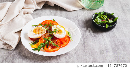 Light appetizer of tomatoes, boiled egg, cheese and arugula on a plate web banner Light appetizer of tomatoes, boiled egg, cheese and arugula on a plate web banner 124787670