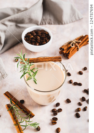 Cup of iced latte with rosemary and cinnamon on the table vertical view Cup of iced latte with rosemary and cinnamon on the table vertical view 124787694