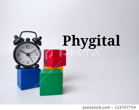 Alarm clock and wooden block with word Phygital on a white background. 124787754