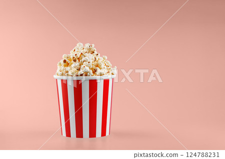 Classic red striped popcorn cardboard cup on Orange background Classic red striped popcorn cardboard cup on Orange background 124788231