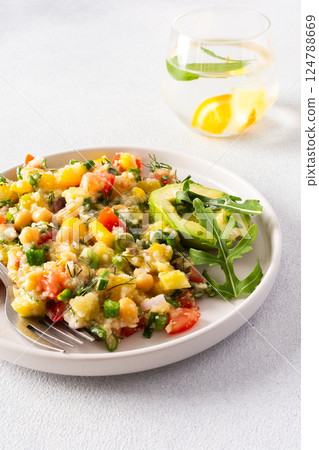 This healthy salad combines boiled millet, chickpeas, fresh vegetables, and avocado, all drizzled with olive oil for a nutritious and flavorful vegetarian meal This healthy salad combines boiled millet, chickpeas, fresh vegetables, and avocado, all drizzled with olive oil for a nutritious and flavorful vegetarian meal 124788669
