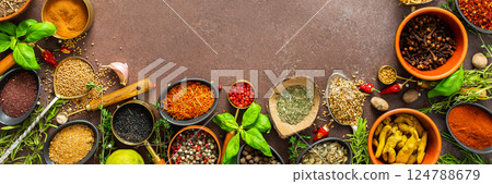 A visually striking arrangement of fresh spices and herbs on a brown surface, highlighting their vivid colors, intricate details, and rich culinary essence, banner 124788679