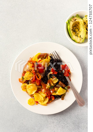 This wholesome breakfast includes black rice with stewed vegetables, stewed tomatoes, zucchini, peppers and onions top view This wholesome breakfast includes black rice with stewed vegetables, stewed tomatoes, zucchini, peppers and onions top view 124788707