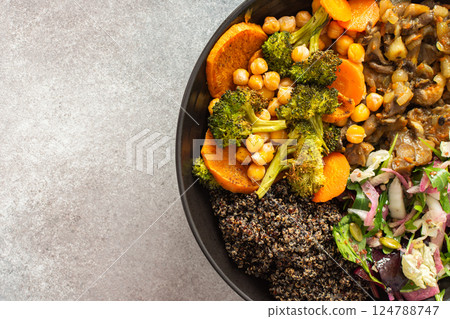 A wholesome breakfast of black quinoa, avocado, baked chicken, roasted vegetables like sweet potato, zucchini, and broccoli, along with a fresh salad of cabbage, radish, and chia seeds 124788747
