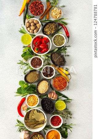 A beautiful display of cooking spices and dried herbs on a gray background, offering a palette of natural hues ideal for culinary inspiration 124788781