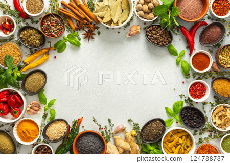 Fresh and colorful spices and herbs arranged in a frame on a gray background, adding natural beauty and culinary charm, top view and copy space 124788787
