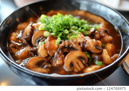 Savory oatmeal cooked in chicken broth, topped with fried mushrooms and green onions, creating a rich and hearty meal perfect for breakfast or lunch 124788975