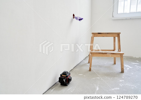 The electrical outlet is unfinished, the wires are rewound with purple electrical tape. A wooden stand next to the laser equipment. There is a place to copy. High quality photo 124789270