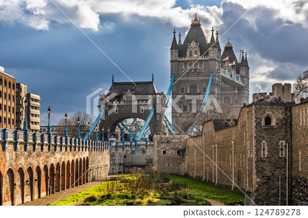 Tower Bridge rising behind medieval Tower of London fortress 124789278