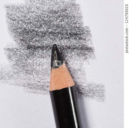 Close up of a sharpened black pencil with visible graphite shading on white paper Close up of a sharpened black pencil with visible graphite shading on white paper 124789828