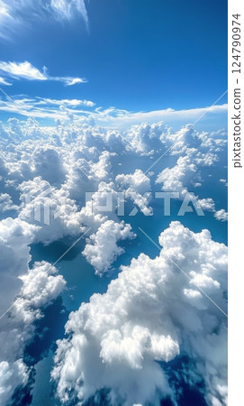 Vibrant blue sky with fluffy white clouds creating a tranquil landscape above 124790974