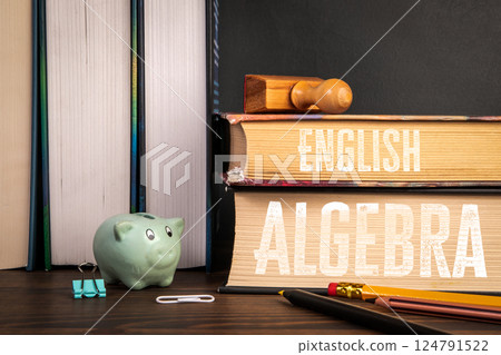 Books on English and Algebra with Piggy Bank and Office Supplies on Desk Books on English and Algebra with Piggy Bank and Office Supplies on Desk 124791522