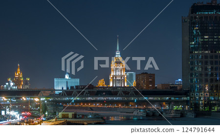 Hotel Ukraine and pedastrian bridge timelapse, landmark near historic center of Moscow. Cityscape in snowy winter evening. Hotel Ukraine and pedastrian bridge timelapse, landmark near historic center of Moscow. Cityscape in snowy winter evening. 124791644