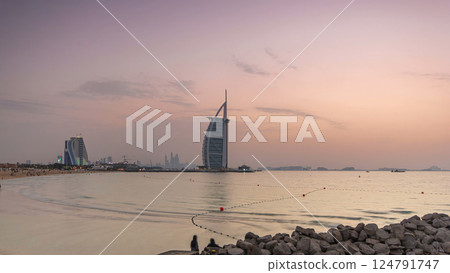 Dubai skyline with Burj Al Arab hotel day to night timelapse. 124791747