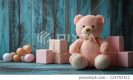 Cute knitted teddy bear surrounded by pastel gifts on a rustic blue wooden background 124792422