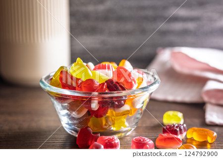The colorful jelly candies in bowl on wooden table. 124792900