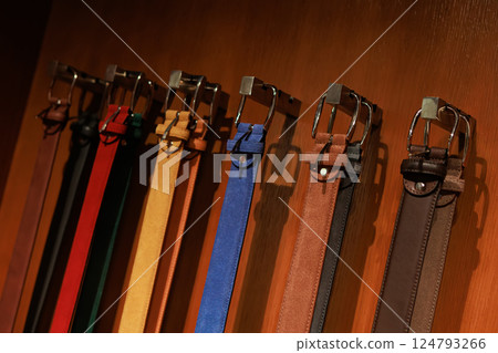 A group of multi-colored leather belts on display. 124793266