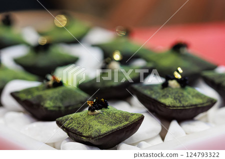 Luxurious matcha-infused dessert with a velvety green coating Luxurious matcha-infused dessert with a velvety green coating 124793322