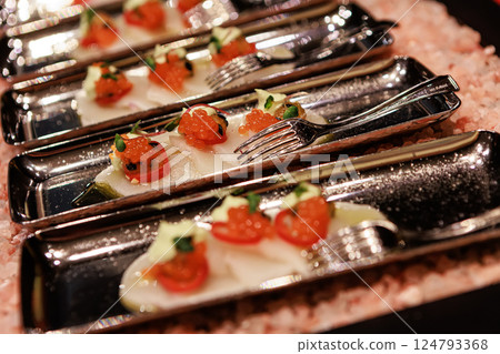 Elegant seafood appetizer featuring thinly sliced scallops, garnished with vibrant salmon roe Elegant seafood appetizer featuring thinly sliced scallops, garnished with vibrant salmon roe 124793368