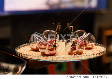 Elegant gourmet appetizers served in tilted glassware on a stylish crystal platter Elegant gourmet appetizers served in tilted glassware on a stylish crystal platter 124793379