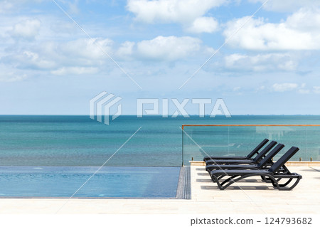 Tranquil view of an infinity pool at the sea coast with a relaxing atmosphere Tranquil view of an infinity pool at the sea coast with a relaxing atmosphere 124793682