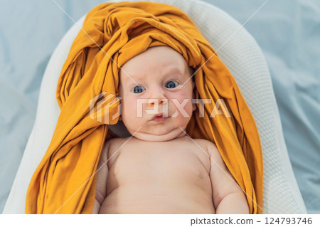 Newborn baby comfortably resting in a cozy baby nest. Safe and peaceful sleep concept for infants 124793746