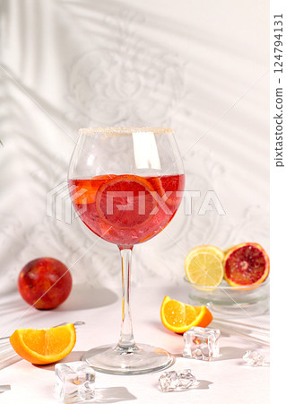Aperol Spritz cocktails with lemon and orange, ice cubes, rum and tequila. Summer party and holiday concept. Banner with alcoholic drinks and tropical fruits. Menu for a bar or cafe. Aperol Spritz cocktails with lemon and orange, ice cubes, rum and tequila. Summer party and holiday concept. Banner with alcoholic drinks and tropical fruits. Menu for a bar or cafe. 124794131