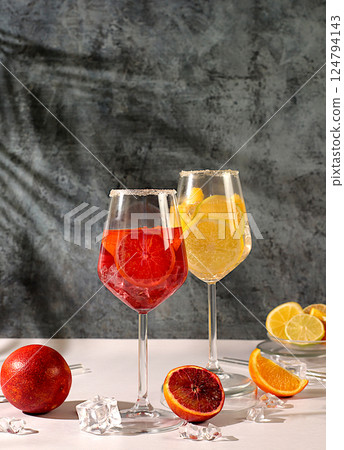 Aperol Spritz cocktails with lemon and orange, ice cubes, rum and tequila. Summer party and holiday concept. Banner with alcoholic drinks and tropical fruits. Menu for a bar or cafe. Aperol Spritz cocktails with lemon and orange, ice cubes, rum and tequila. Summer party and holiday concept. Banner with alcoholic drinks and tropical fruits. Menu for a bar or cafe. 124794143