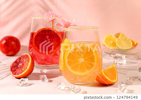 Royal cocktail of blood orange, lemon and lime, ice cubes, rum and tequila. Flyer with a glass of alcoholic drink and tropical fruits. Summer party concept. Menu for a bar or cafe. Royal cocktail of blood orange, lemon and lime, ice cubes, rum and tequila. Flyer with a glass of alcoholic drink and tropical fruits. Summer party concept. Menu for a bar or cafe. 124794149
