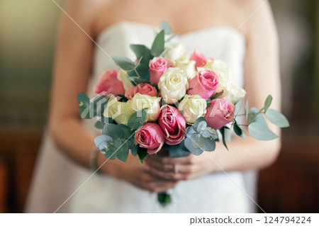 Bride, hand and rose bouquet, flowers and wedding decoration with plants on marriage ceremony day. Flower, hands and woman in dress holding plants for marriage event with scent, fragrance and beauty 124794224
