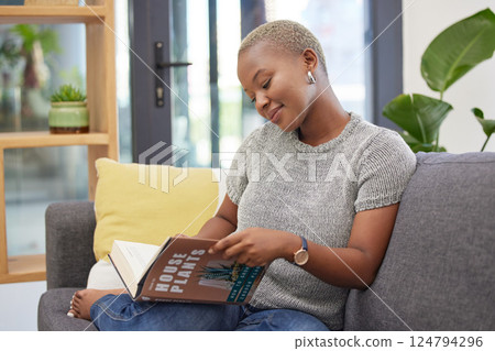 Plant care, learning and woman reading gardening book for instructions, tips and ideas for home garden. Greenery, nature and black woman relaxing, sitting on sofa and read manual for house plants 124794296