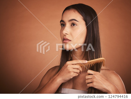 Beauty, hair and woman with comb in studio with luxury hair care for healthy and clean hairstyle. Health, wellness and grooming, beautiful model girl combing straight hair style on brown background. 124794416