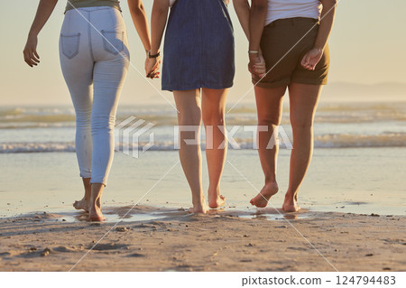 Friends, girl group and back at beach for walk on vacation, holiday or summer travel together in sunshine. Legs, holding hands and women walking to relax in ocean sand, sea or water in solidarity 124794483
