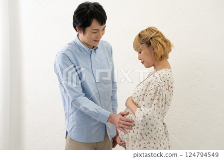 丈夫把手放在懷孕妻子的肚子上 丈夫把手放在懷孕妻子的肚子上 124794549