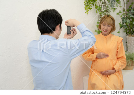 Husband taking pictures of his pregnant wife Husband taking pictures of his pregnant wife 124794573