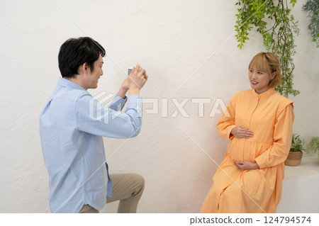 Husband taking pictures of his pregnant wife Husband taking pictures of his pregnant wife 124794574