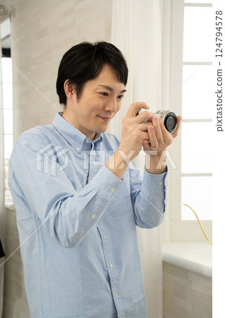 Man taking a picture with a digital camera 124794578